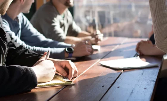 People taking notes around table for Work Related Stress counselling