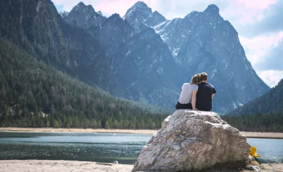 Couple sitting on rock in front of lake and mountains for relationship issues counselling